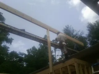Carpenter setting a ridge beam over a new addition frame — Ice Dam Removal by Roofing Brothers in Bradfordsville