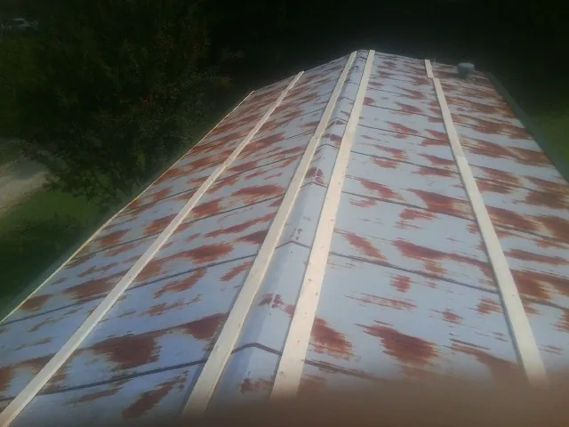 Rusted metal roof panels with new wood purlins before replacement — Storm Damage Roof Repair in Bradfordsville by Roofing Brothers