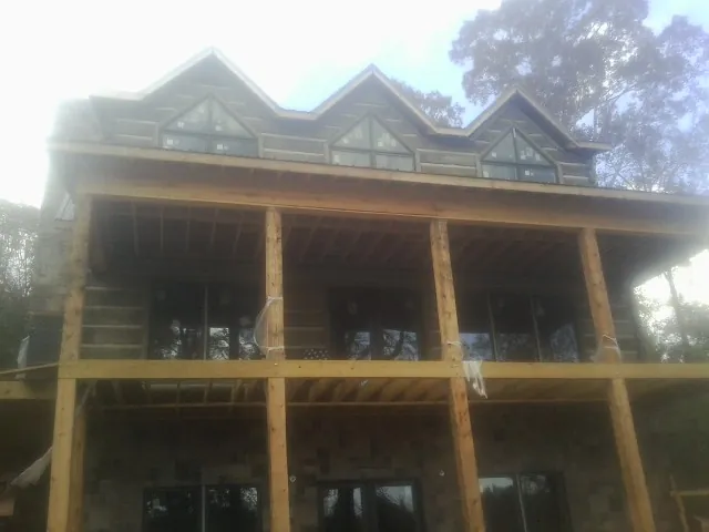 Dormers and porch framing on a large log home under construction — Roof Coating work by our crew in Bradfordsville